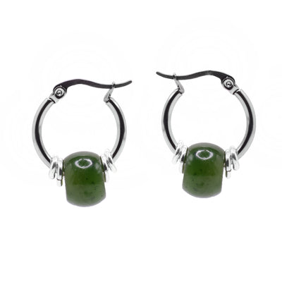 These beaded hoop earrings have large, sterling silver hoops with genuine BC jade beads in the center of them. The hoops have a wide gauge and a wide, oval jade bead in the center. There are two small, silver hoops on both sides of the bead and lever hooks at the top.