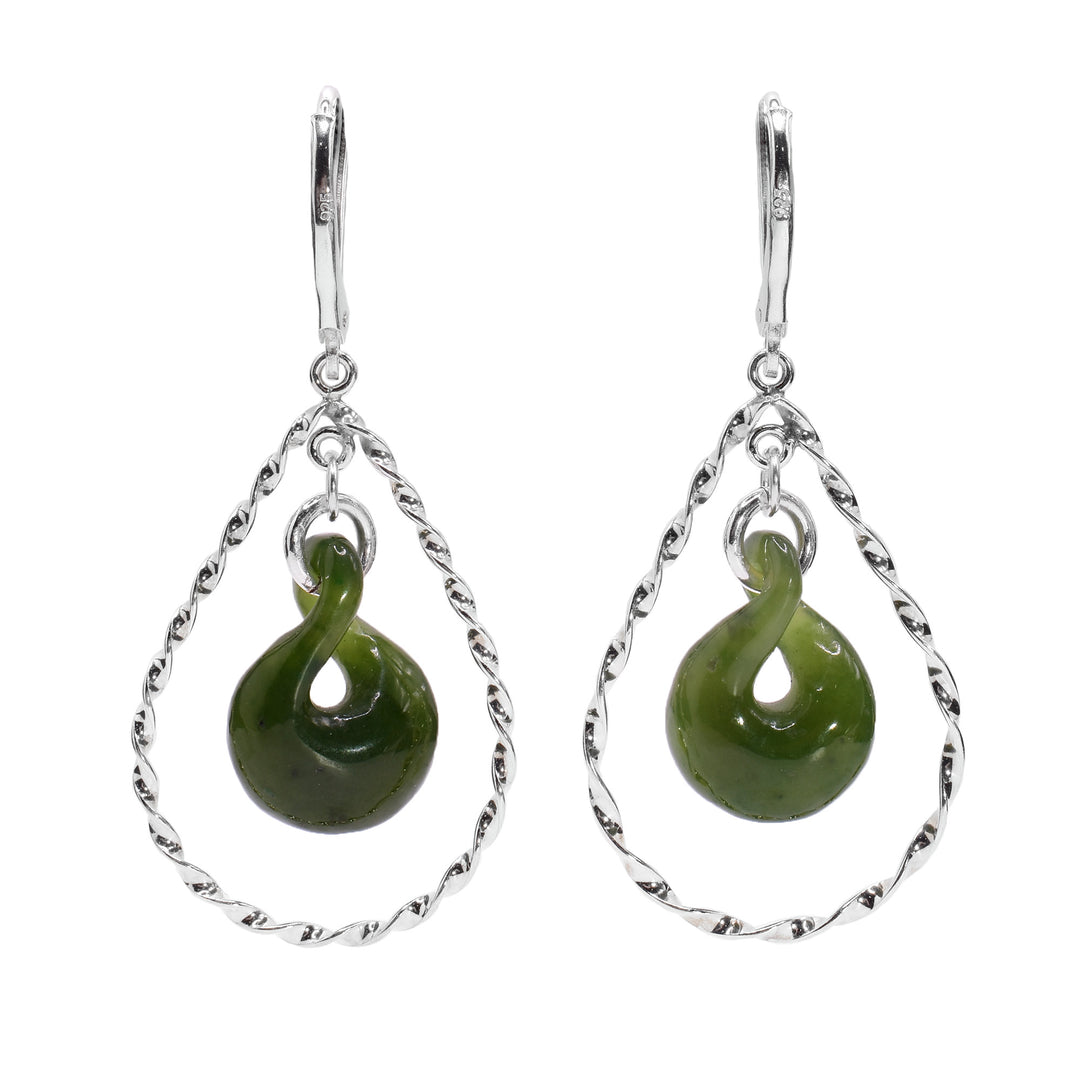 These dangling jade earrings have a teardrop shaped jade gem with a twisted design that are framed with sterling silver, teardrop shaped hoops. The hoops are thin and are much wider than the jade pieces. They also have a textured appearance because they are finely twisted.