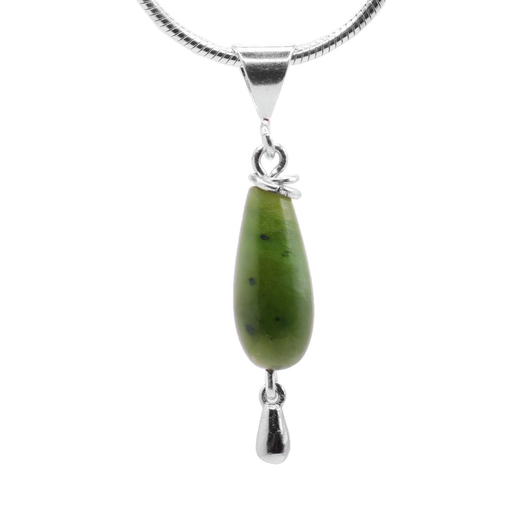 This jade pendant has a long, teardrop shaped jade gemstone hanging from a sterling silver bail and has a silver teardrop dangling from the gem.