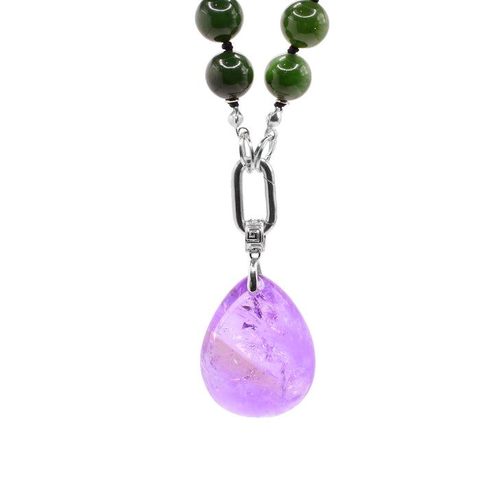 This jade beaded necklace has sphere shaped jade beads that are separated with spacers. There is a sterling silver chain link with a detachable amethyst pendant that is teardrop shaped.