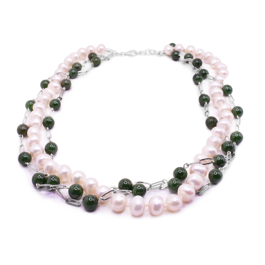 This jade and pearl necklace has a single, sterling silver chain with spherical, pearl beads. There are two sterling silver chains with jade beads, spaced out around them, that are wrapped around the pearl beads. The chains with the jade beads have large, sterling silver chain links between the jade beads.