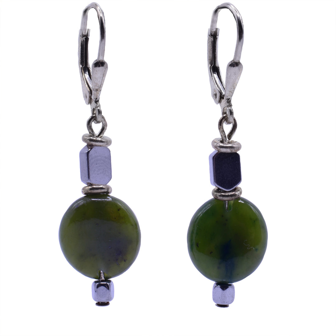 These leverback BC jade drop earrings feature hematite spacers. The top bead is a hematite spacer bead. Below that is a larger, round bead of BC jade. The bottom of the earring is finished with a small, rounded square of hematite. The beads are separated by simple silver rings.