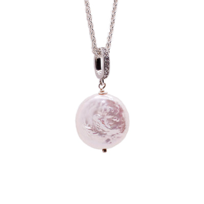 A sterling silver chain with a big, flat, round pearl pendant. The pendant has a big, textured bail.