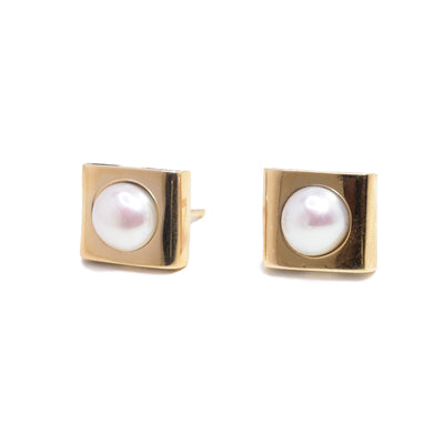 These pearl stud earrings are made from sterling silver and are square shaped. The top layer is made from 14K gold and has a freshwater pearl in the center of each earring.