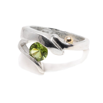 This sterling silver peridot ring is split at the top to hold a peridot gemstone. At the top of the ring is a 14K gold ball.