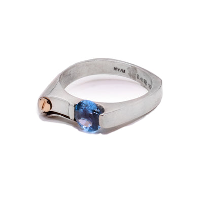 This dainty signet ring is made from sterling silver. There is a 14K gold stud and a blue topaz gemstone on the signet of the ring.