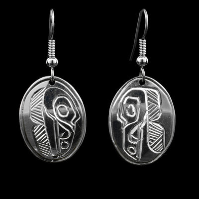 These sterling silver dangle earrings have oval shaped hangs with depictions of the Raven carved into the surface of them.