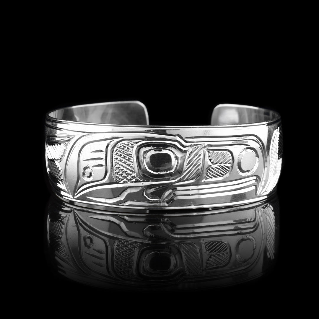 This sterling silver cuff bracelet has a wide band and there are deep carvings on the surface of it that depict the Thunderbird.