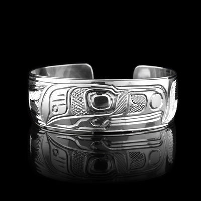 This sterling silver cuff bracelet has a wide band and there are deep carvings on the surface of it that depict the Thunderbird.