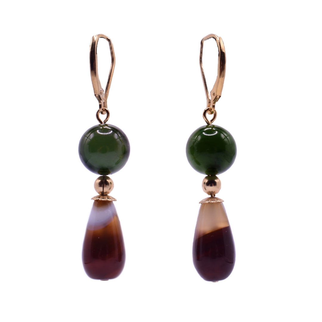 These leverback jade and gold dangle earring are designed with a large, polished spherical bead of deep, BC Jade sits a top a small, filled gold sphere spacer bead. Underneath a polished, teardrop-shaped bead of a tigers eye. This bottom bead transitions from a translucent milky tan at the top to a rich brown at the bottom.