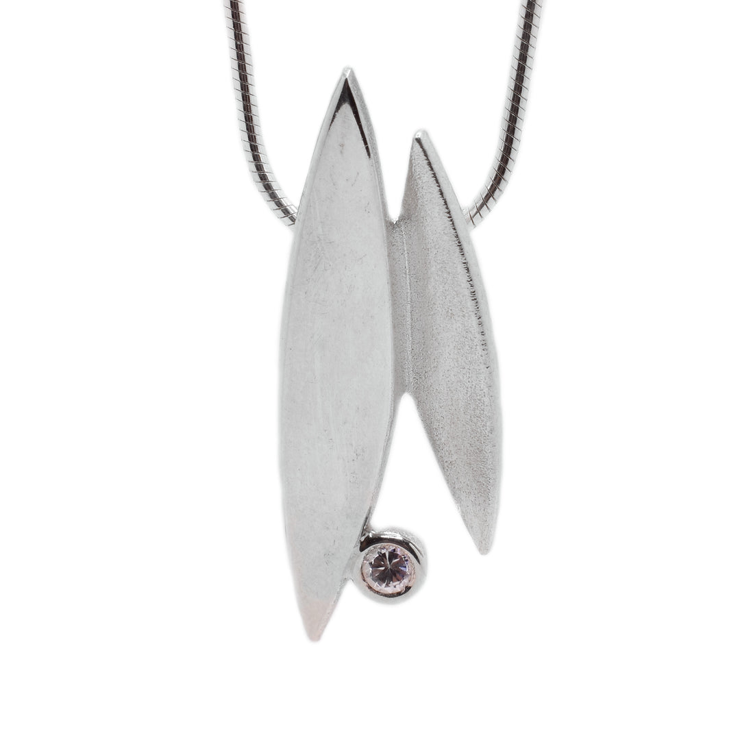This cubic zirconia necklace is made from sterling silver and has a round chain. The pendant consists of two sharp oval shapes attached together with a cubic zirconia gemstone attached at the bottom.