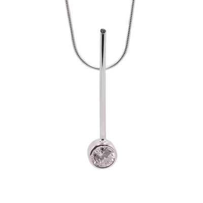 This sterling silver necklace has a round chain and a long, thin, and vertical pendant. The pendant has a cubic zirconia gemstone embedded into it at the bottom.