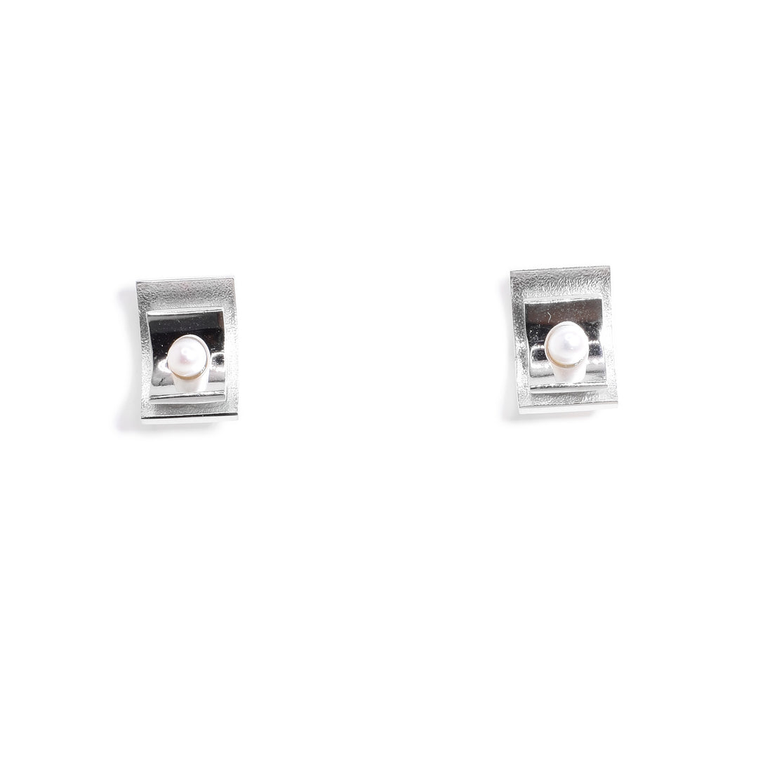 These sterling silver pearl stud earrings have two silver sheets on top of each other with freshwater pearls in the middle.