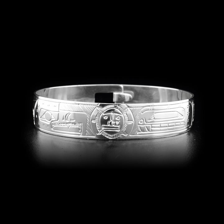 This sterling silver clasp bracelet has depictions of the Orca, the Eagle, and the Sun carved into the band. The Sun is at the top of the band and there is a clasp in the back.
