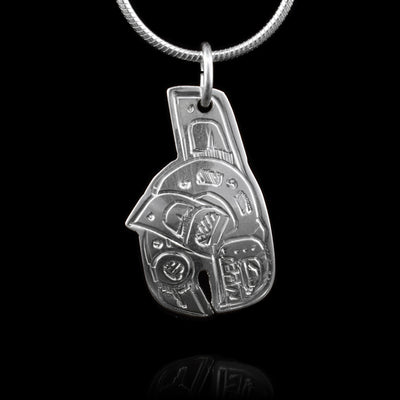 This Orca pendant is made from sterling silver and it is shaped like and has carvings on the surface of it that depict the Orca.