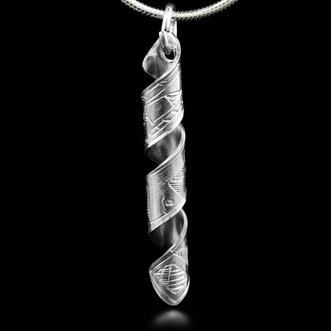 This pendant is made out of a sterling silver strip which has the face and body of the Orca carved on it and then coiled into a spiral.