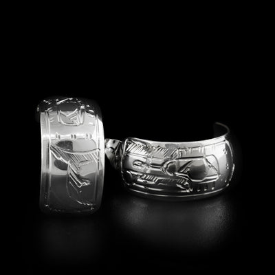 These hoops were carved on a flat piece of sterling silver that depict a head of the Raven holding the Sun.