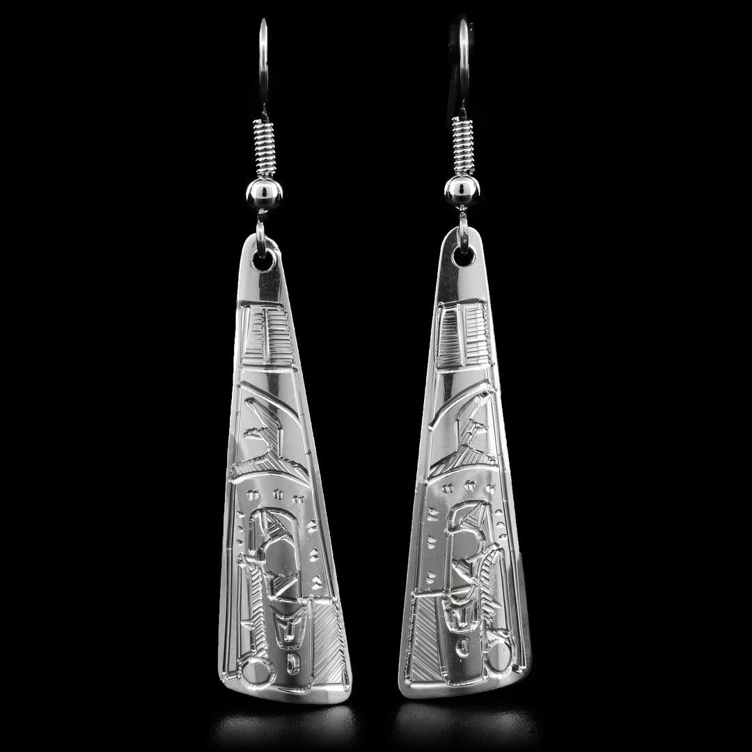 These dangle earrings are carved out of sterling silver. The tringular earrings have a face of the Raven carved on the bottom, looking downward.