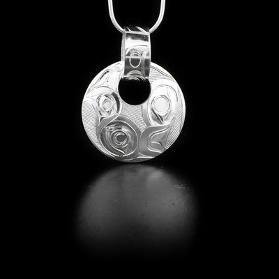 This piece is made from sterling silver  and includes a circle pendant with a small, circle cut out and a hand carved bail running through the cutout. There is a double Eagle pattern carved into the pendant.