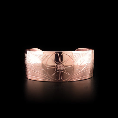 This Hummingbird bracelet is made from copper and has a wide band. There is a depiction of a flower carved into the center of the band, and there are two depictions of the Hummingbird carved into the corners of the brand.