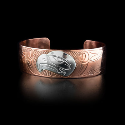 This copper cuff bracelet has carvings that depict the Eagle. The head of the Eagle is made from sterling silver.