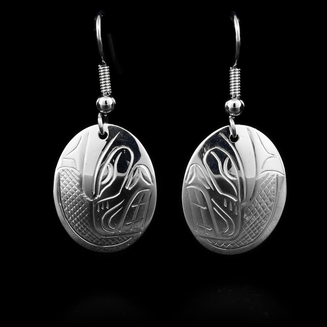 These sterling silver dangle earrings have oval hangs with depictions of the Bear carved into them.