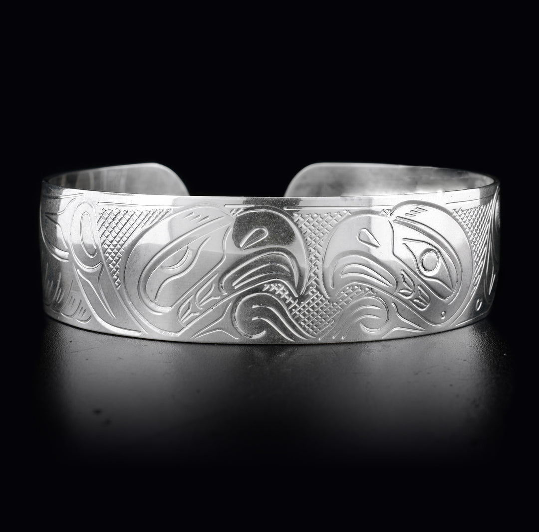This sterling silver Eagle bracelet has a wide band with two depictions of the Eagle carved into it. Their heads meet at the top of the bracelet.