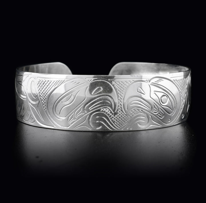 This sterling silver Eagle bracelet has a wide band with two depictions of the Eagle carved into it. Their heads meet at the top of the bracelet.
