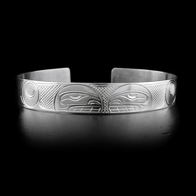 This sterling silver cuff bracelet has two depictions of the Orca carved into it. Thier heads meet at the top of the bracelet.