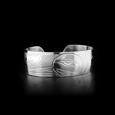 This sterling silver cuff bracelet has a wide band with a gap in the back. There is a depiction of the Hummingbird and a flower carved into the surface of this Hummingbird bracelet.