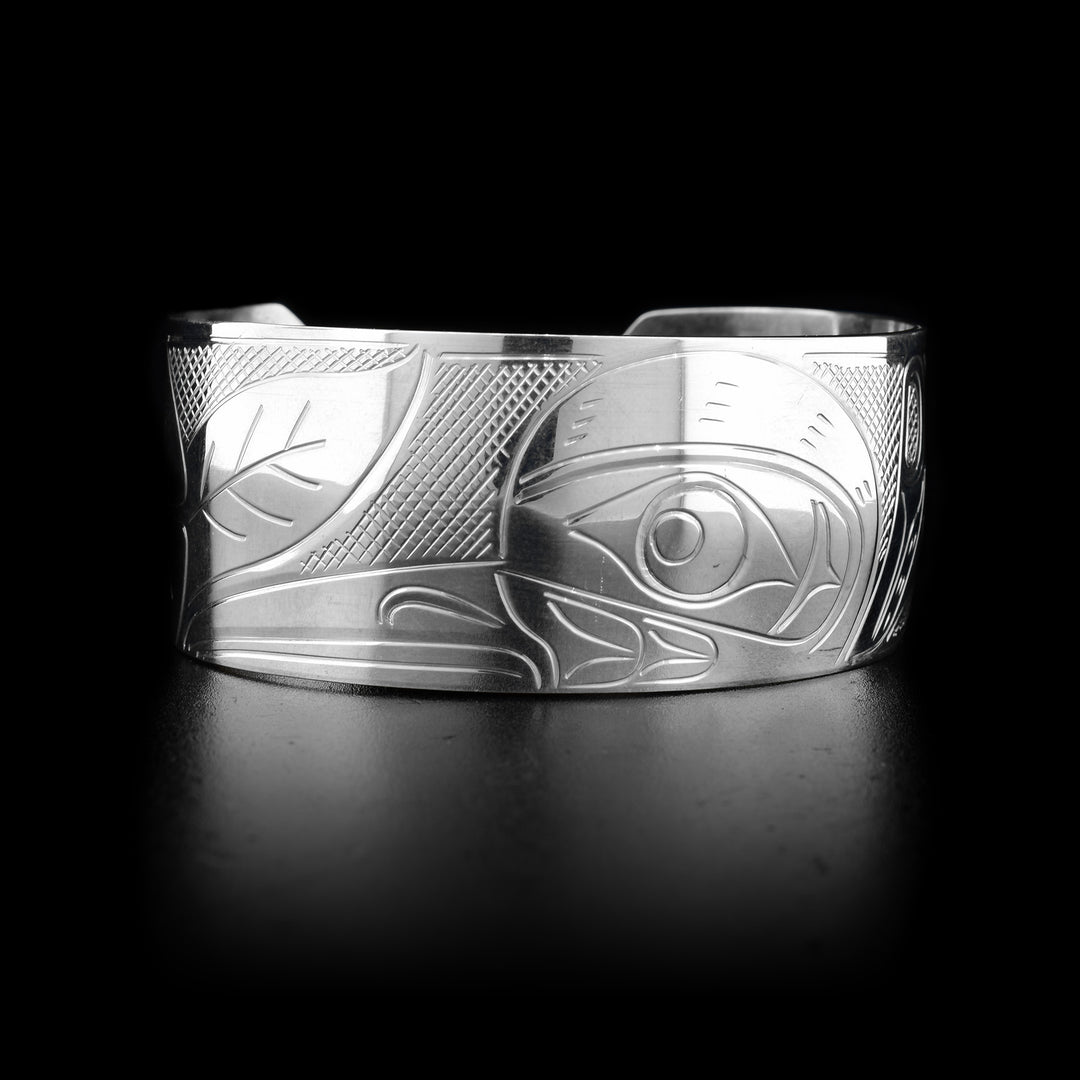 This sterling silver Hummingbird bracelet cuff has a wide band with a flower and a depiction of the Hummingbird carved into it. 