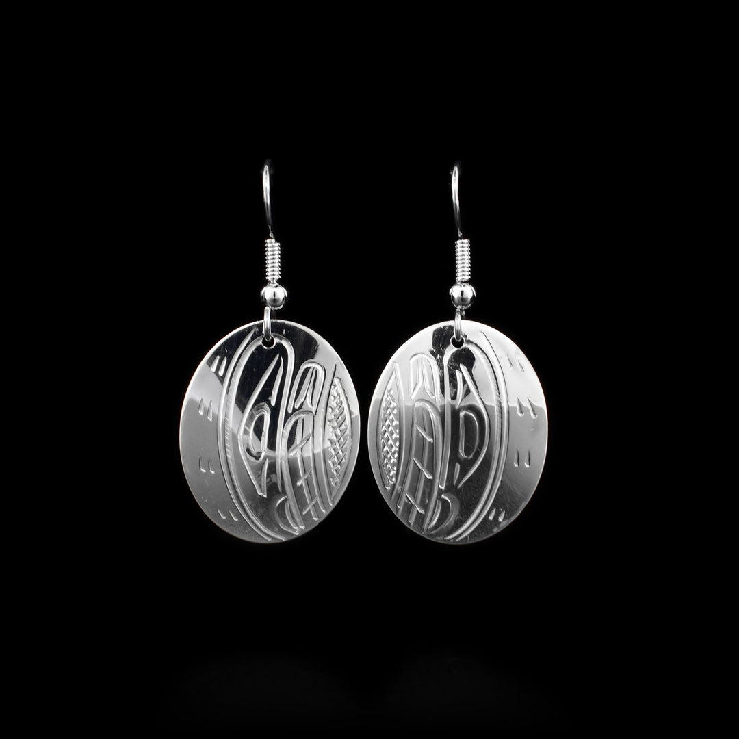 These sterling silver dangle earrings have oval shaped hangs with depiction of the Orca carved into the surface of them.