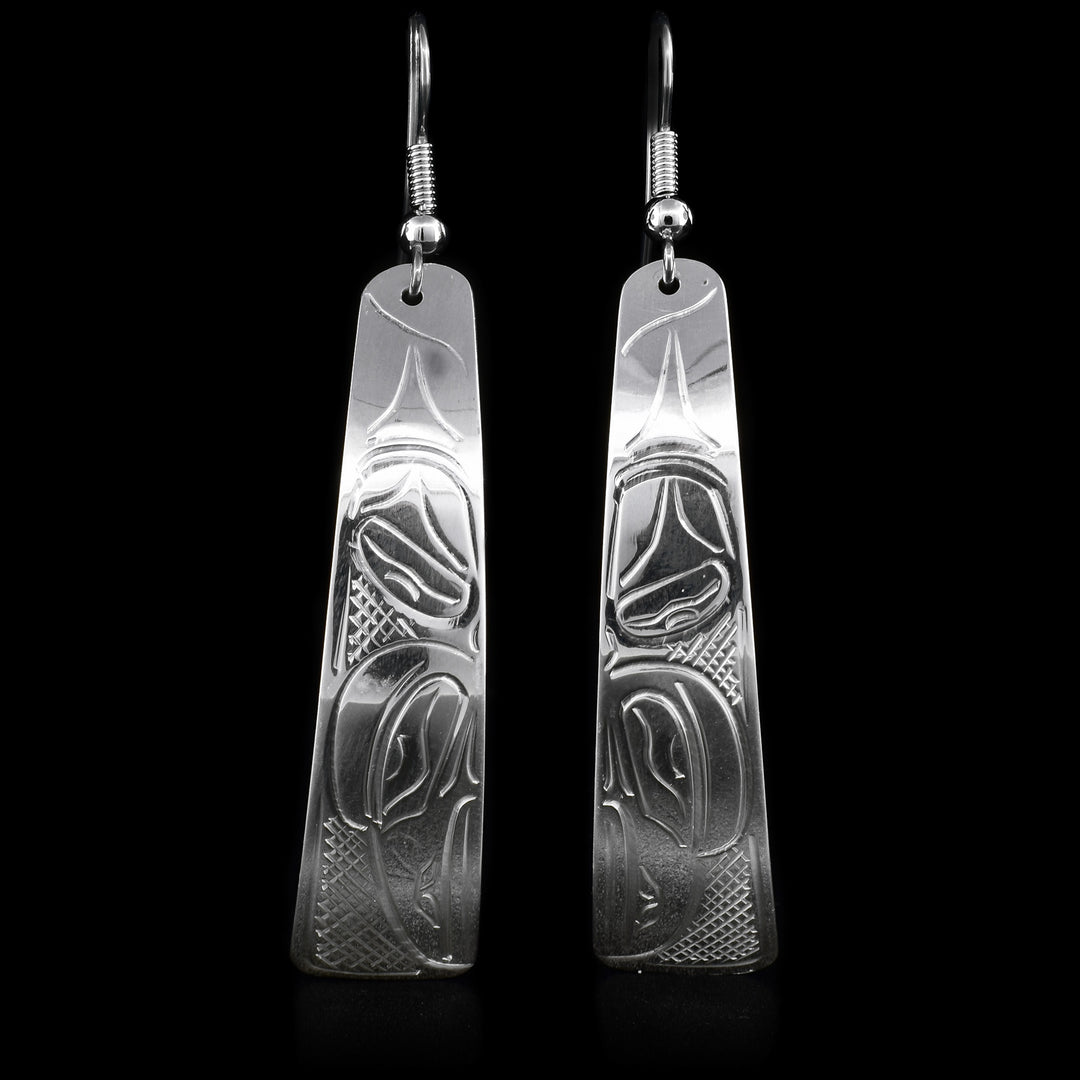 These dangling sterling silver earrings have long hangs and there is a depiction of the Raven carved into it. 