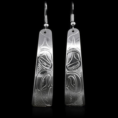 These sterling silver dangle earrings have long hangs and there is a depiction of the Raven carved into it. 