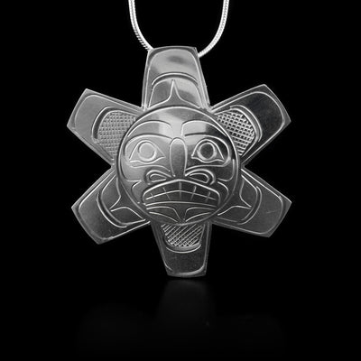 This large, sterling silver pendant is shaped like the Sun and has carvings that depict the Sun on it.