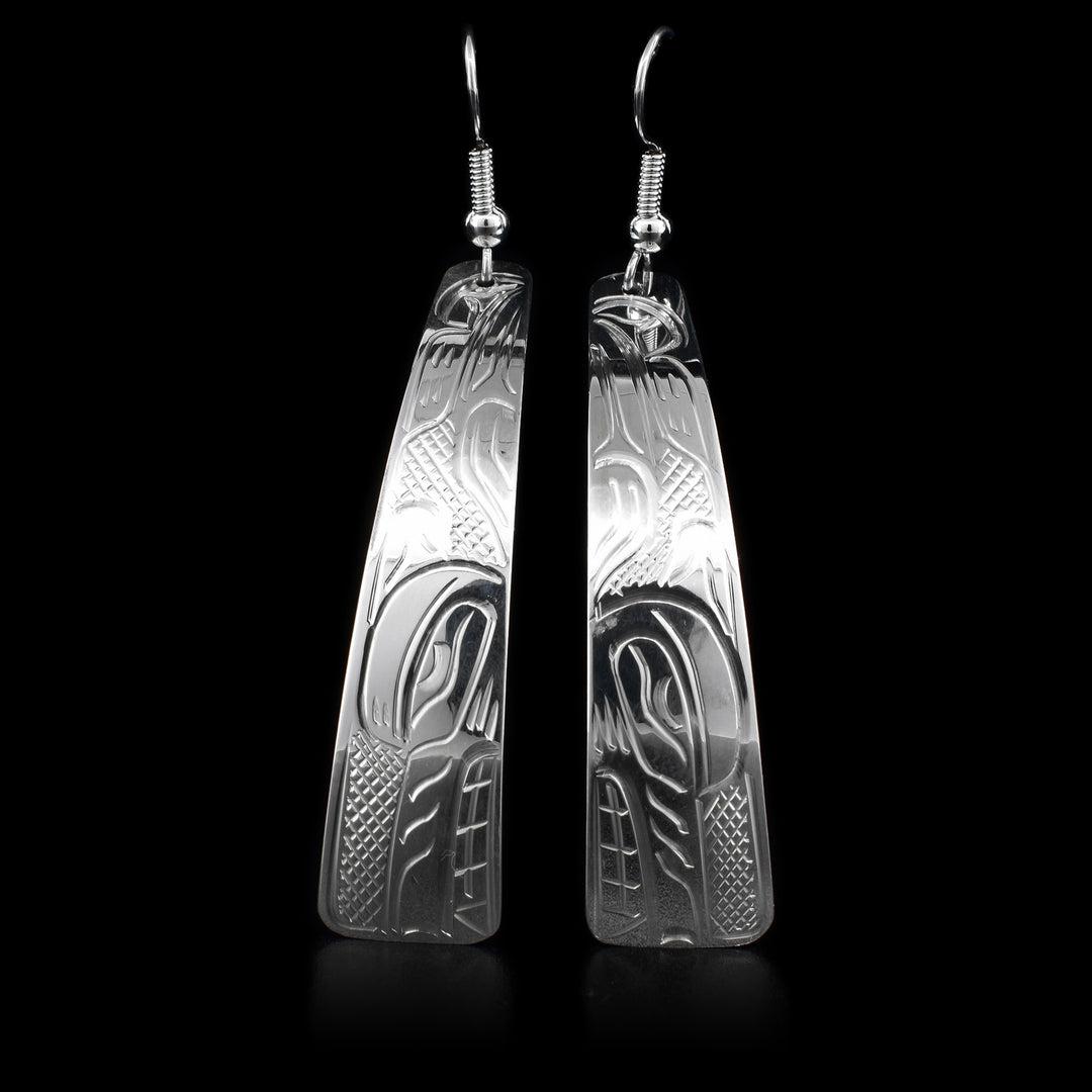 These dangling sterling silver earrings have long hangs with a depiction of the Wolf carved into them.