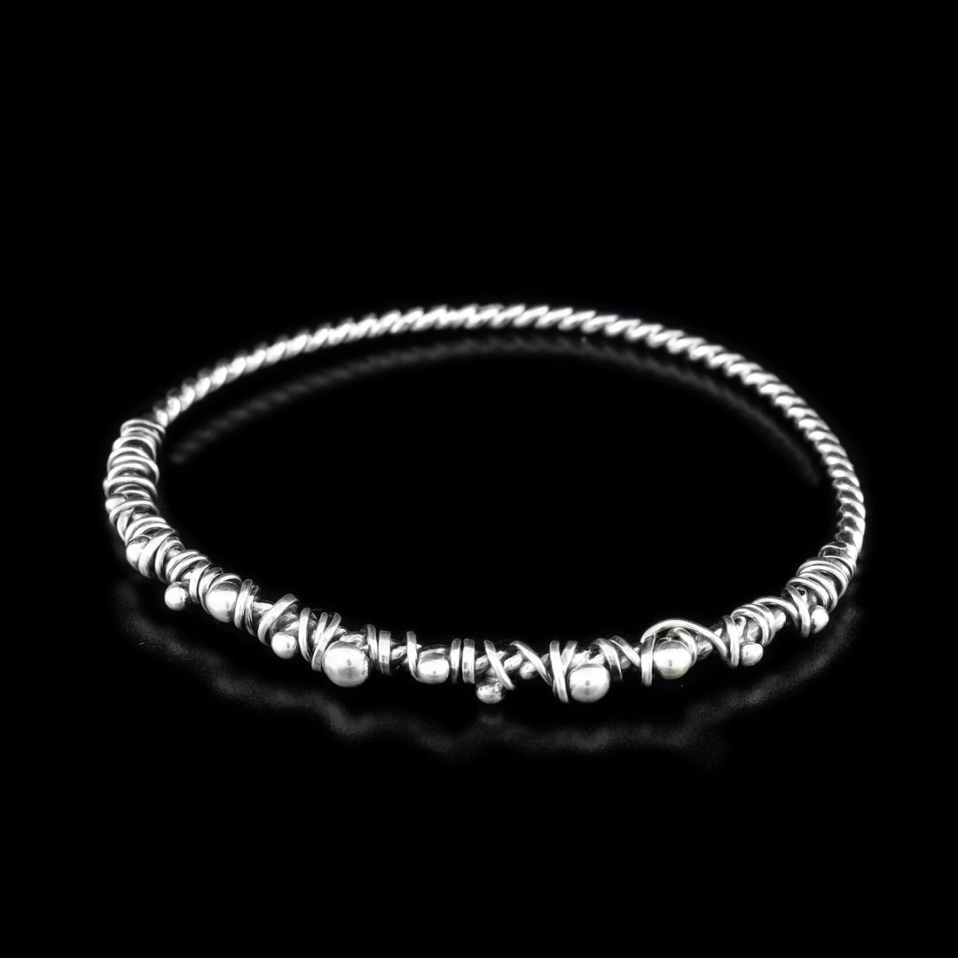 These sterling silver bangle bracelets are made from a coil and has silver wrappings on half of the piece.