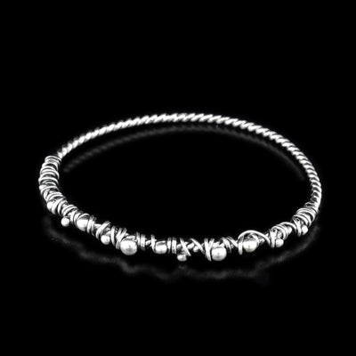 These sterling silver bangle bracelets are made from a coil and has silver wrappings on half of the piece.