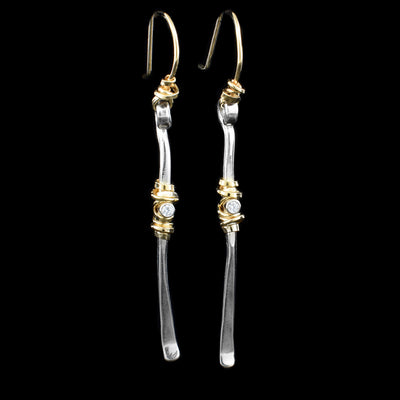 These drop, cubic zirconia earrings have gold fill hooks and long sterling silver rods attached to them. On the rods are cubic zirconia gemstones with gold fill wrapped around them.