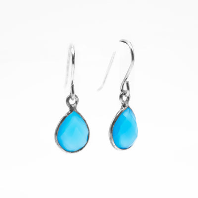 Both earrings are a flat, faceted, teardrop blue chalcedony set in silver, hanging from a hook. All metal is sterling silver.