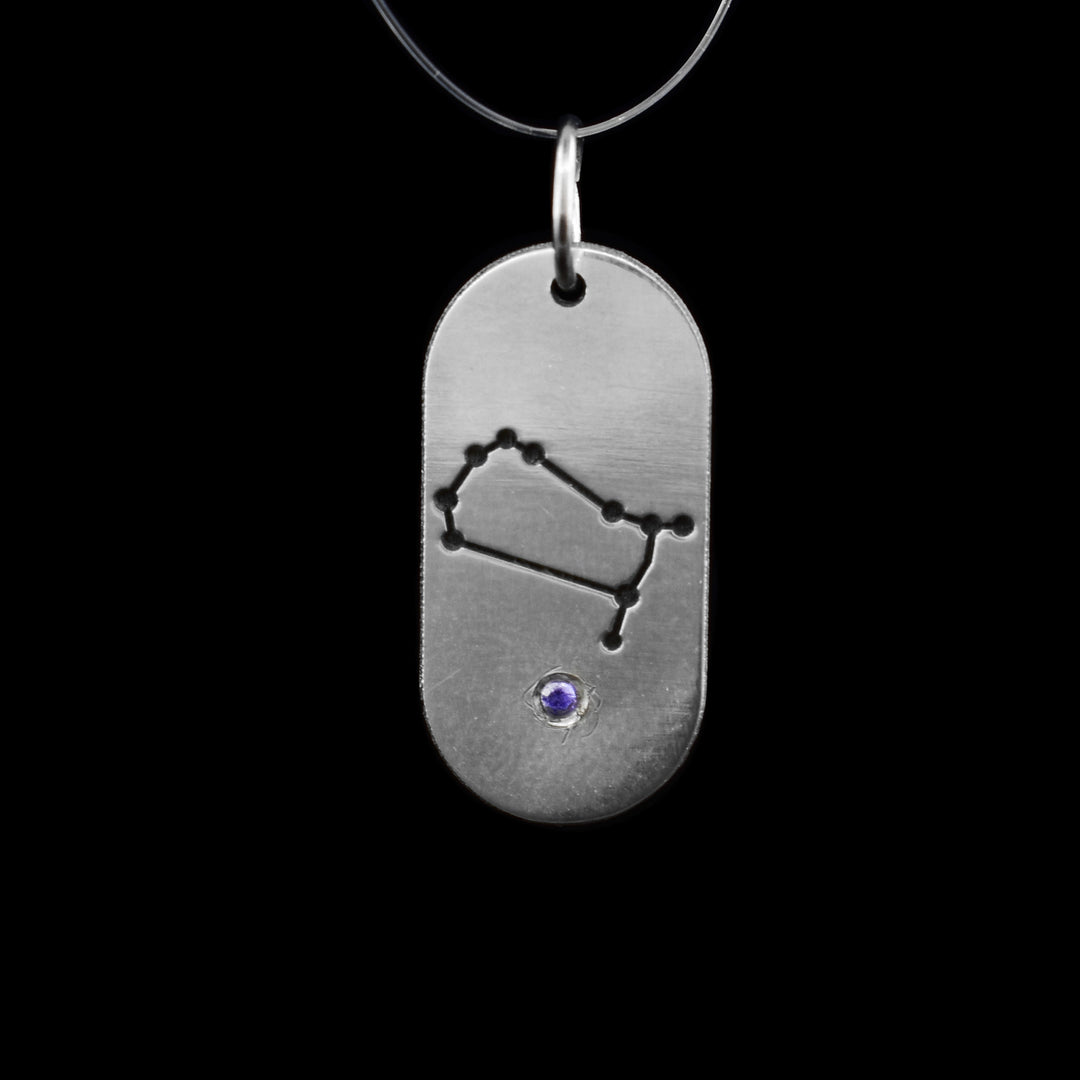 This June Zodiac Sign Pendant, crafted in sterling silver, showcases the delicate constellation of Gemini, celebrating those born in June. At the base, a radiant purple cubic zirconia represents the June birthstone.