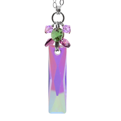 This brilliant crystal necklace is made from multiple Swarovski crystal, sterling silver and a large paradise shine Swarovski Crystal. The paradise shine crystal is long, rectangular and dangles from silver chain links. Around these links are pink and green crystal also hanging from links.