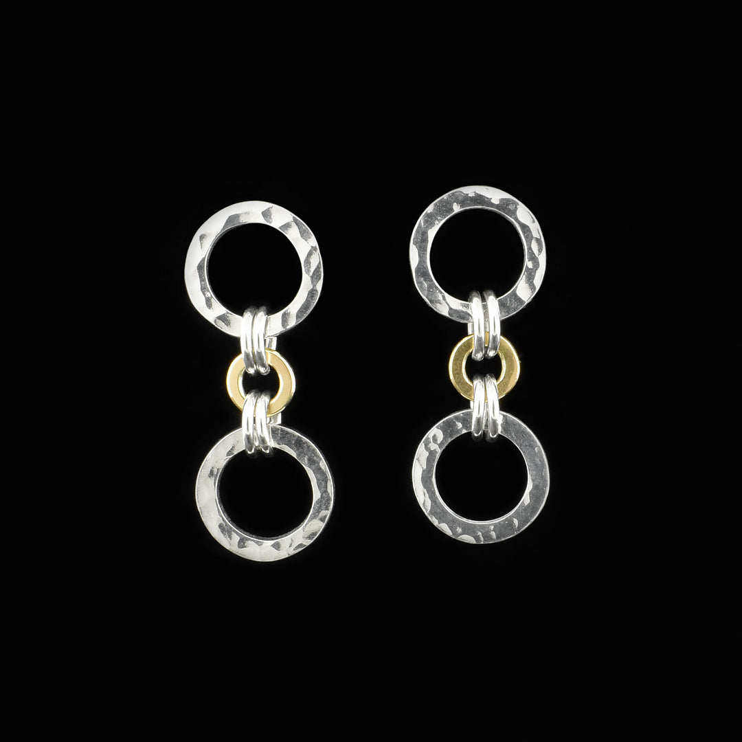 Studs are made up of rings. Two big sterling silver ones on top and bottom with dented effect. Small 14K gold one in middle connected to big rings by sterling silver jump rings.