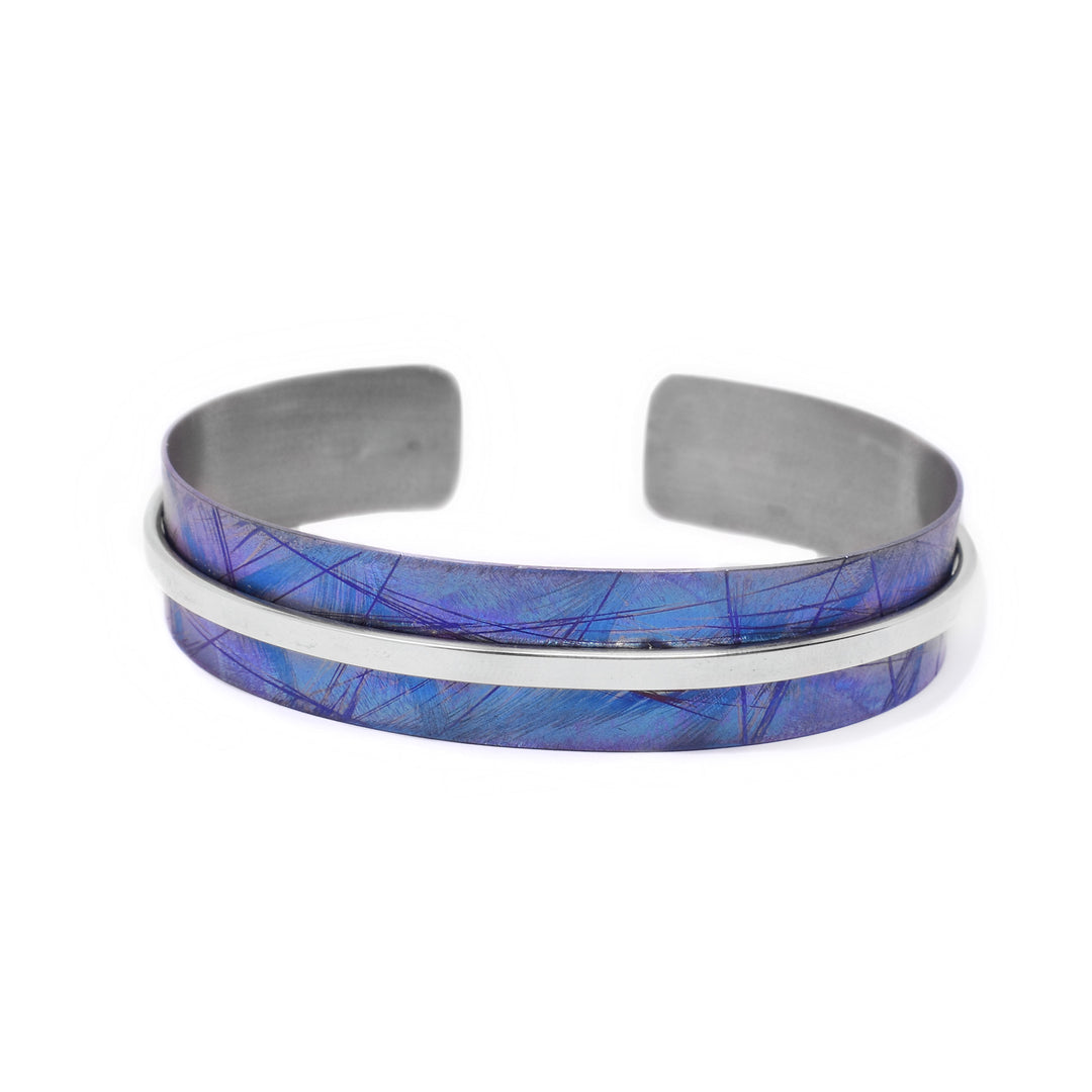 0.56” wide cuff made of anodized titanium. Colour is purple blue. Thin strip of sterling silver goes all the way across the middle, contrasting the blue.