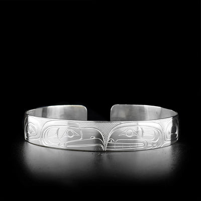 Sterling silver cuff bracelet featuring eagle and orca facing each other.