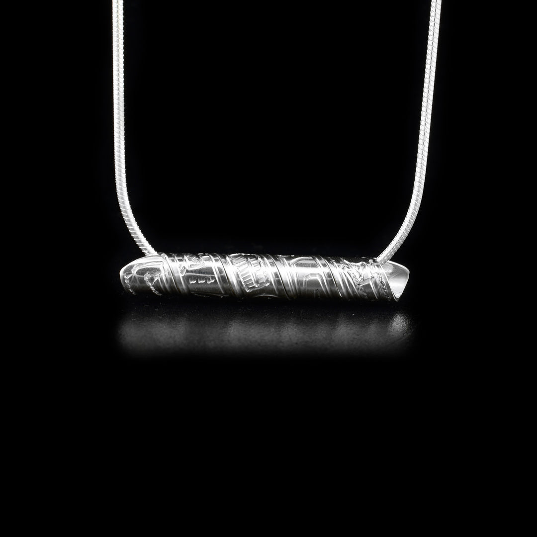 Strip of sterling silver depicting eagle, wrapped into a spiral. Horizontal.