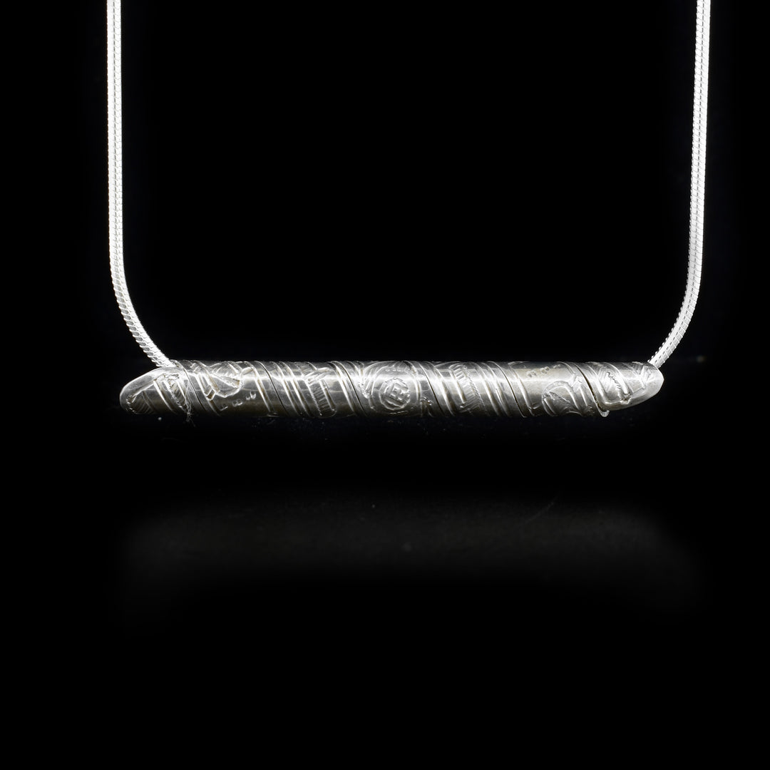 Strip of sterling silver depicting hummingbird, wrapped into a spiral. Horizontal.