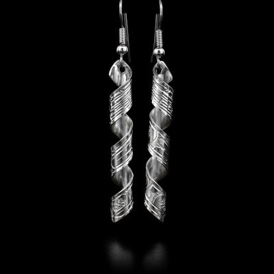 Both sterling silver earrings are a long rectangle, featuring an orca, twisted into a spiral. By Coast Salish artist Gilbert Pat.