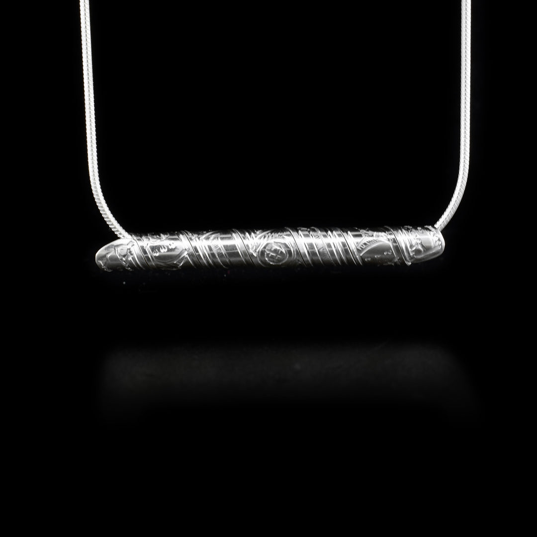 Strip of sterling silver depicting raven, wrapped into a spiral. Horizontal.