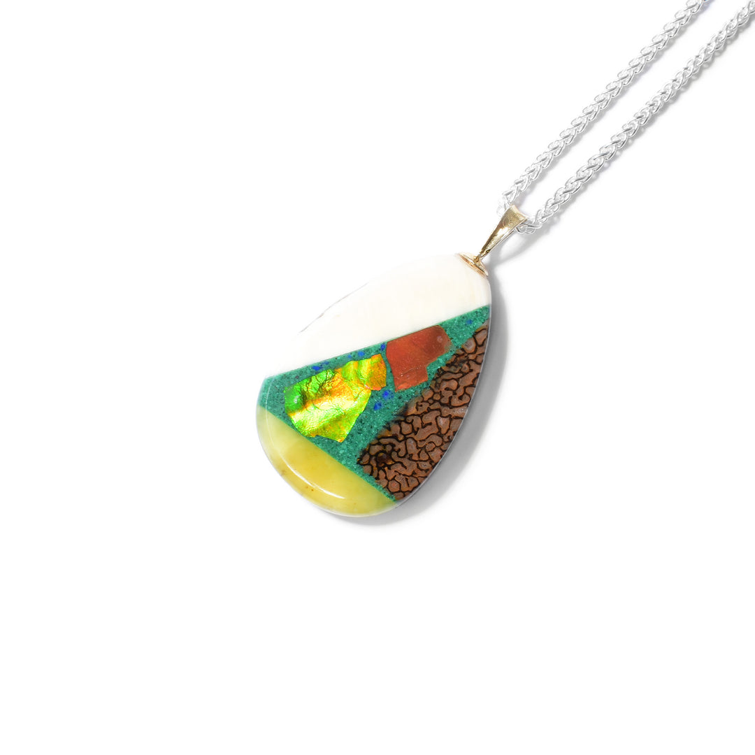 Pear shape. Pendant is a mosaic of sugilite, rhodochrosite, lapis, malachite, dinosaur bone, turquoise, amber, mammoth ivory and ammolite. 14K gold bail.